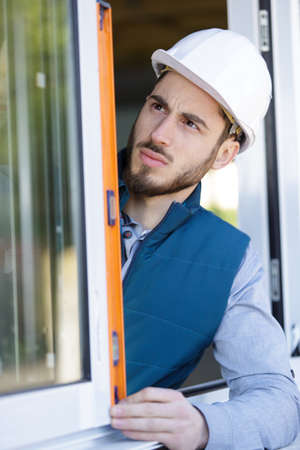 glazier checking installation with spirit levelの写真素材