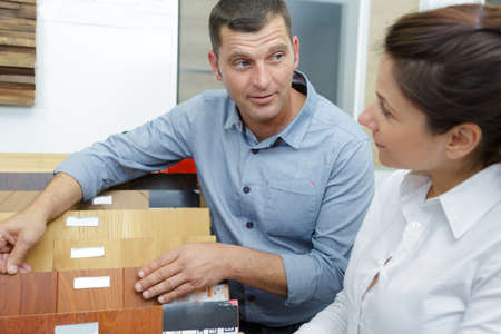 salesman showing wood flooring samples to customerの写真素材