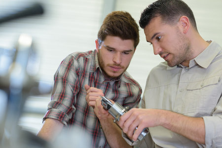 two workers assembling metal components
