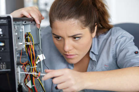 young female pc technician fixing a pcの写真素材