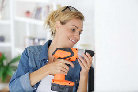 woman worker drilling something at construction siteの写真素材