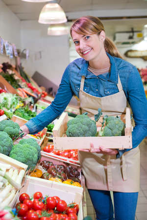 female staff holding broccoli in organic sectionの写真素材