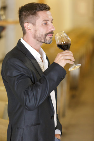man tasting a wine in a cellar