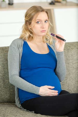 young beautiful woman holding electronic cigarette e-cigaretteの写真素材