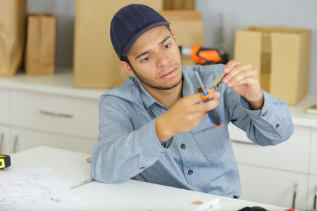 Young male worker assembling flat packed kitchen
