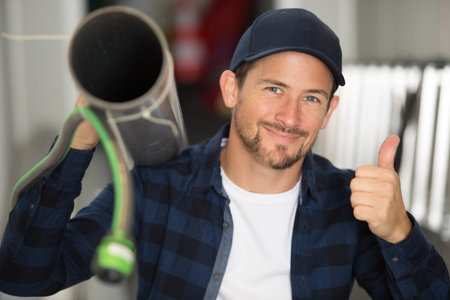 Plumber with pipe wrench shows the thumb up