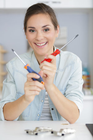 Woman holding two types of screwdrivers