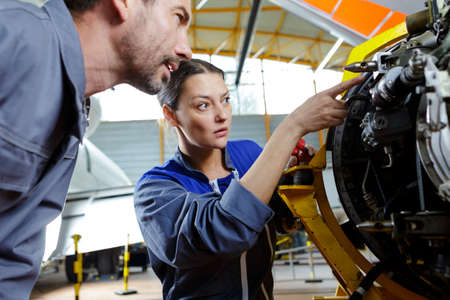 female mechanic fixing a compressor engineの写真素材