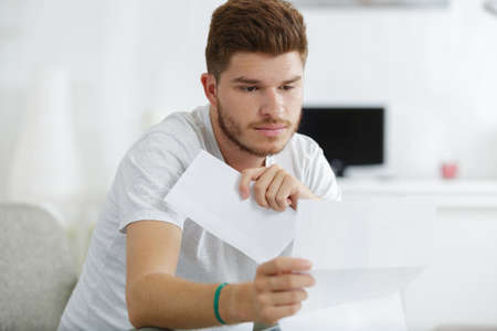 Man reading letter and upset bad news mailの写真素材