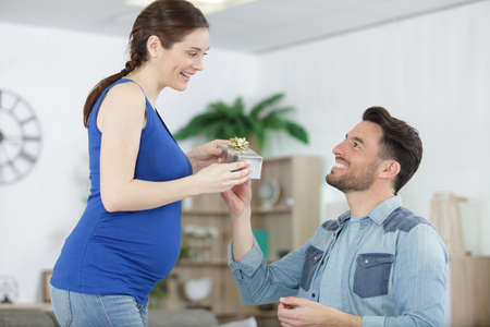 man offering present to pregnant wifeの写真素材