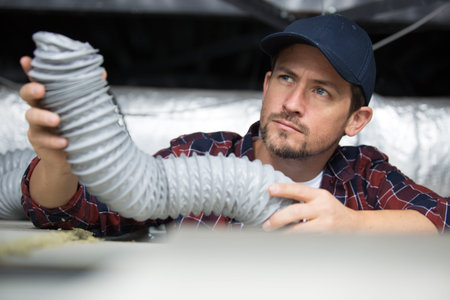 worker inspects the wiring for ventilation