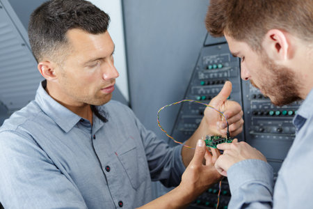 two workers dealing with electricity indoors