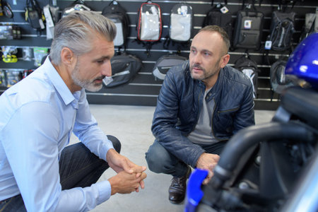 client and seller discussing motorcycle at motorbike dealer
