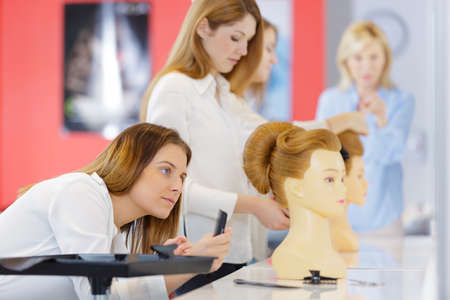 future hairdresser practicing on the mannequins artificial hairの写真素材