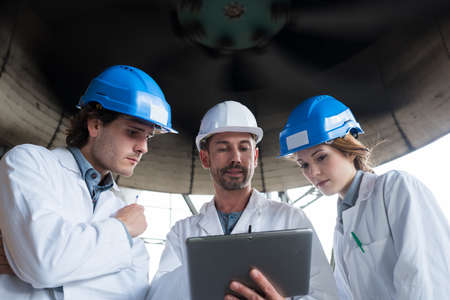 workers in a factory looking at a tableの写真素材