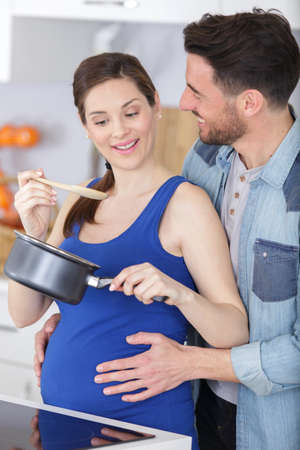Couple cooking together in their kitchen at homeの写真素材