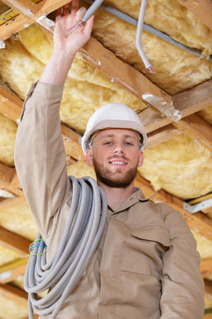 happy builder mounting for an electric cable in ceilingの写真素材
