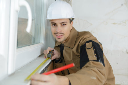 young builder installing cassette roller blinds on windows