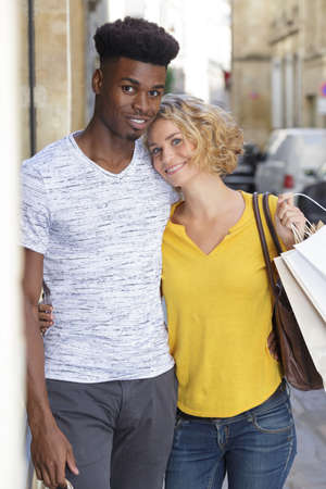 happy couple with shopping bags outdoorsの写真素材