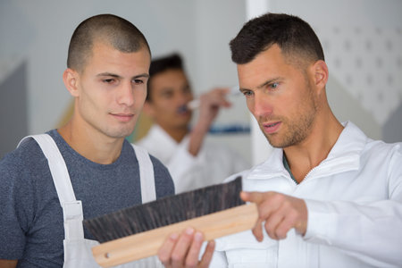two men inspecting a brush