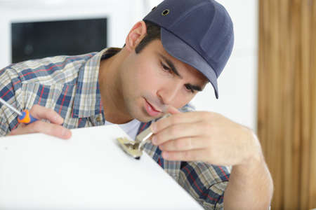 locksmith repair lockpicker on white slide doorの写真素材
