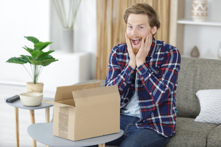 exited young male next to a cardboard boxの写真素材