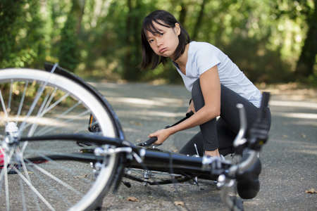 annoyed woman pumping up a bike tireの写真素材