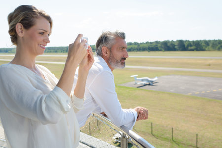 woman taking photograph looking down over airfield