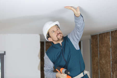house renovation worker checking the alignment of a ceilingの写真素材