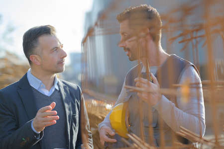 manual worker talking to manager by rebarsの写真素材