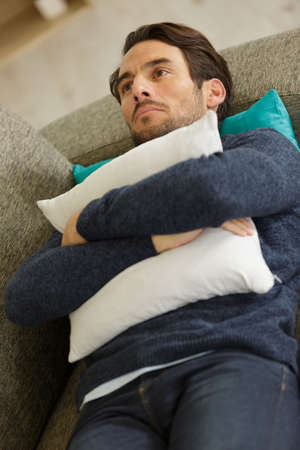 depressed man layed on the sofaの写真素材