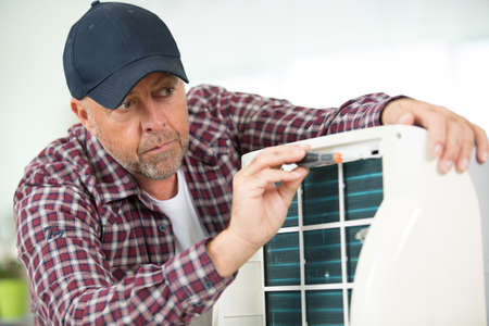 man trying to repair the air conditioningの写真素材