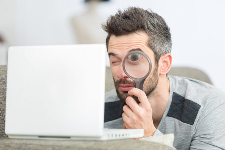 businessman with magnifying glass and laptop