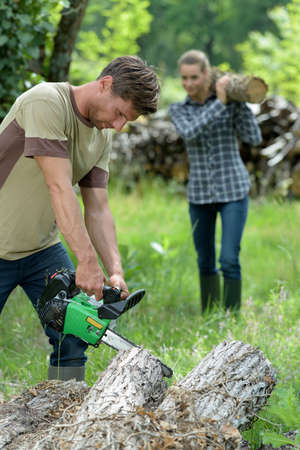 lumberjack working with chainsaw in a forestの写真素材