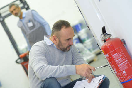 a professional checking fire extinguisherの写真素材