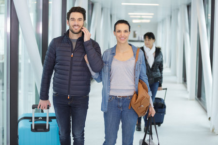 happy couple walking on airport corridor