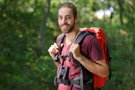 young man hiking looking at camera