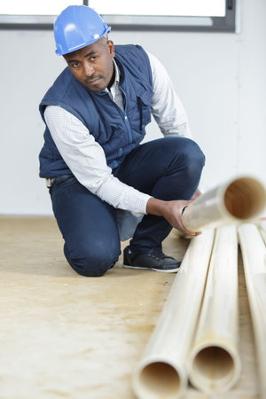 male worker dealing with pipes on the floor