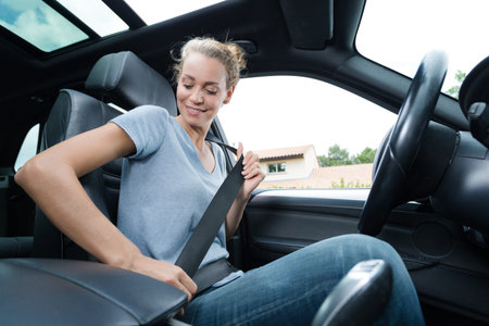 portrait of cute young woman putting her seat belt on