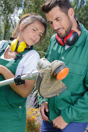 Gardeners checking a garden tool