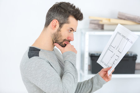 man studying the furniture blueprint