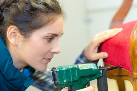 woman fixing a chair with staple