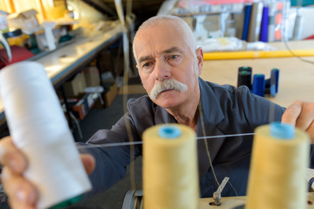 male tailor working with threads