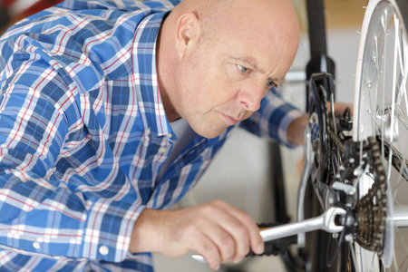 man fixing bike wheel in store