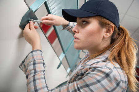 professional female worker using spanner to undo nutの写真素材