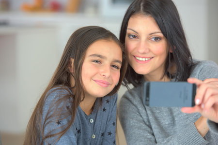 young lady and little sister taking selfie