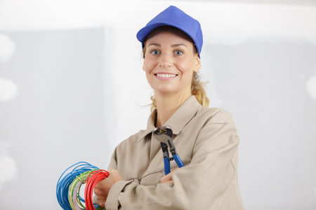 happy female electrician fixing electricity problem