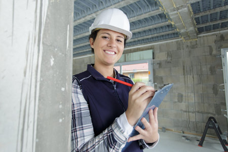 portrait of a young female builder holding a clipboard