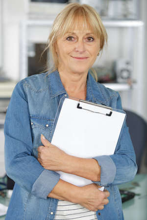 pensive woman with clipboard and penの写真素材
