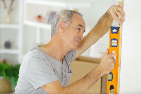 senior man using spirit levelの写真素材